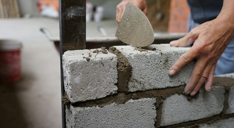 Bricklayer laying blocks with a trowel